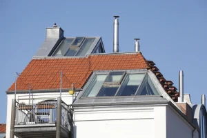 Modernes Dachgeschoss mit großen verglasten Dachgauben auf einem roten Ziegeldach.