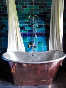 Bad mit Badewanne in Blechoptik und blauen Fliesen