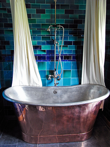 Bad mit Badewanne in Blechoptik und blauen Fliesen