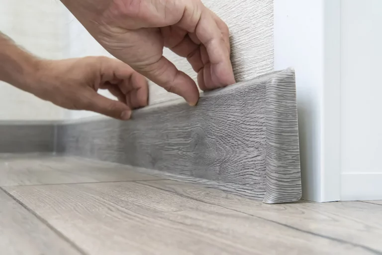 © Eine Kunststoff-Sockelleiste wird demontiert