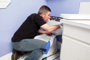 Klempner installiert Spülkasten einer neuen Toilette.
