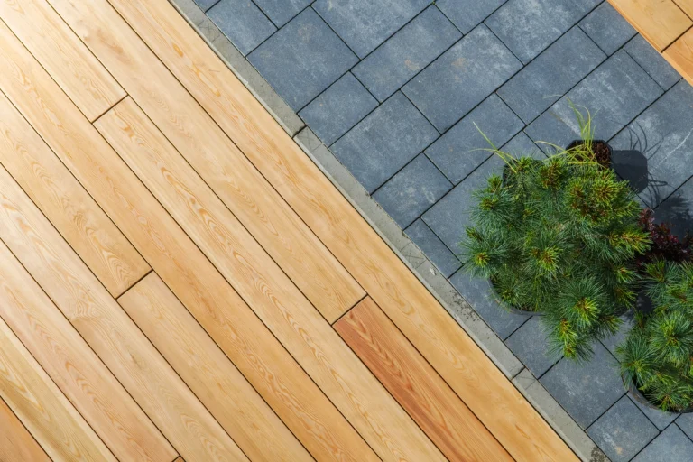 Moderne Terrasse mit Holzdielen aus Douglasie neben grauen Pflastersteinen.
