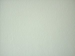 Eine glatte, helle Wandoberfläche mit leichter Textur. Die Wand erscheint gleichmäßig, ohne Dekorationen oder Verzierungen.