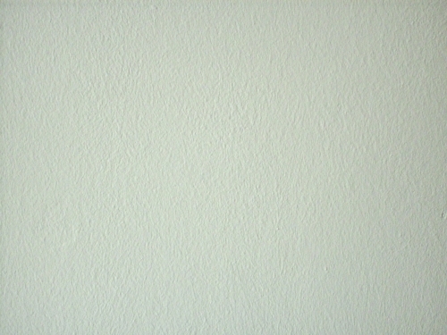Eine glatte, helle Wandoberfläche mit leichter Textur. Die Wand erscheint gleichmäßig, ohne Dekorationen oder Verzierungen.