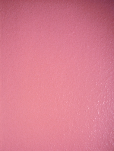 Einfarbige rosa Wand mit einer leicht strukturierten Oberfläche.