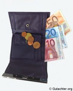 Eine offene Geldbörse aus Stoff mit mehreren Euromünzen und drei Eurobanknoten (50, 20 und 10 Euro) sichtbar. Die Geldbörse hat einen Druckknopfverschluss und liegt auf einem hellen Hintergrund.