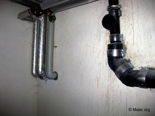 Rohre an einer Wand mit Wasserschaden