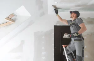 Maler verputzt Deckenwand