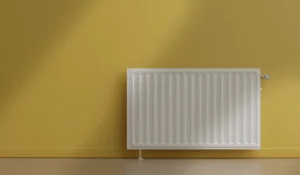 Flachheizkörper an einer gelben Wand.