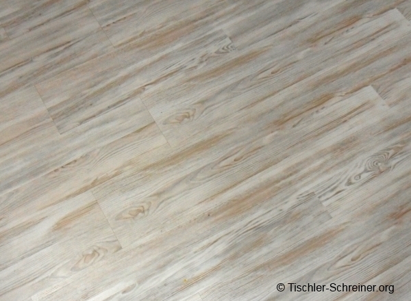 Heller Vinylboden in Holzoptik mit natürlicher Maserung und leicht grauer Tönung, verlegt in klassischer Längsrichtung.