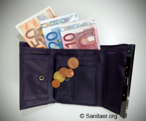 Eine geöffnete schwarze Geldbörse liegt auf einem Tisch. Aus ihr ragen mehrere Euro-Banknoten heraus. In den Münzfächern sind verschiedene Euro-Cent-Münzen sichtbar. Auf der unteren rechten Ecke des Bildes ist ein Logo mit der Aufschrift „Sanitaer.org“.