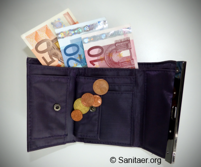 Eine geöffnete schwarze Geldbörse liegt auf einem Tisch. Aus ihr ragen mehrere Euro-Banknoten heraus. In den Münzfächern sind verschiedene Euro-Cent-Münzen sichtbar. Auf der unteren rechten Ecke des Bildes ist ein Logo mit der Aufschrift „Sanitaer.org“.