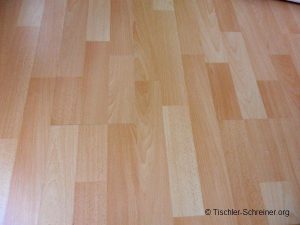 Nahaufnahme eines hellen Laminatbodens in Holzoptik mit abwechslungsreicher Maserung in warmen Beigetönen.