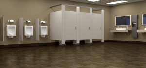 Öffentliche Herrentoilette mit drei Urinalen an der Wand, drei geschlossenen Toilettenkabinen daneben und einem Waschbereich mit zwei Waschbecken und Spiegeln. Der Boden ist mit braunen Fliesen ausgelegt und die Wände sind beige.