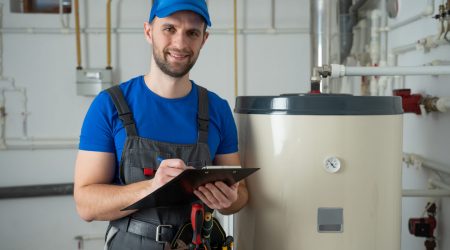 Heizungsbauer neben einer Heizungsanlage