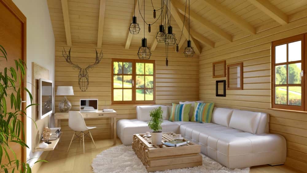 Helles Wohnzimmer mit Holzverkleidung, weißer Eckcouch, modernem Kronleuchter und Arbeitsplatz unter einem offenen Holzbalkendach.