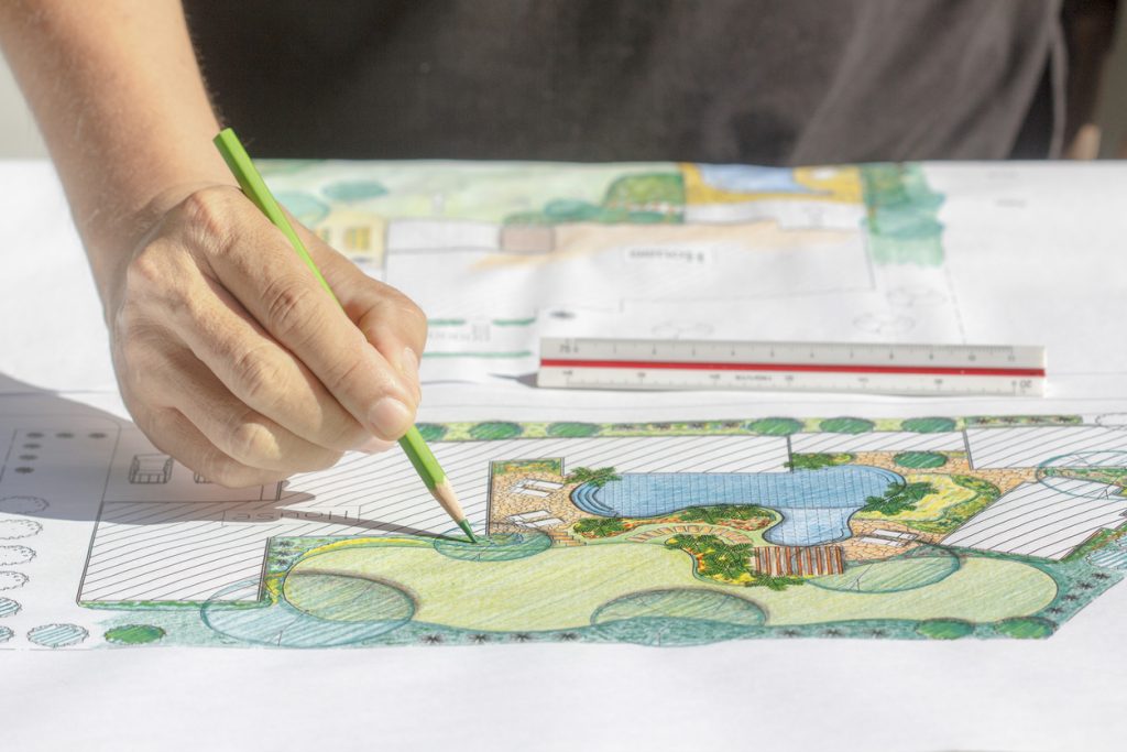 Fachkundiger liest Skizze einer Gartenanlage aus