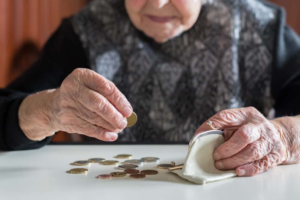 Ältere Frau zählt Geld auf dem Tisch