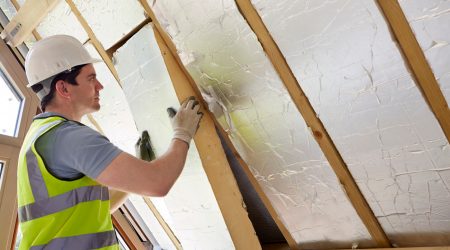 Arbeiter bringt ökologische Dachdämmung an