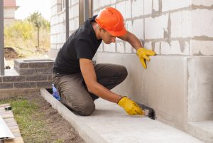 Arbeiter trägt Dichtschlämme auf