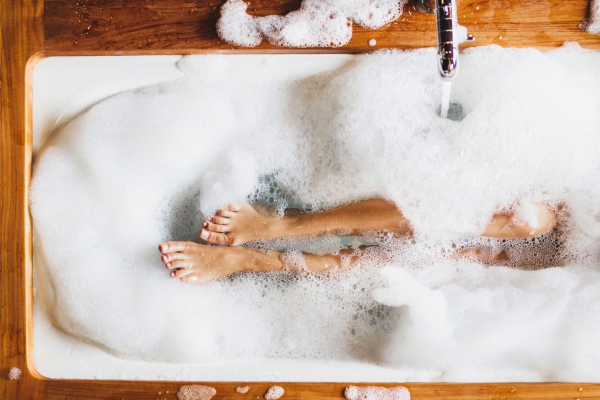 Frau liegt in einer Badewanne mit Schaum