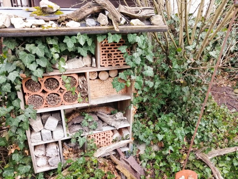 Frontalansicht eines selbst gebauten Insektenhotels im Garten