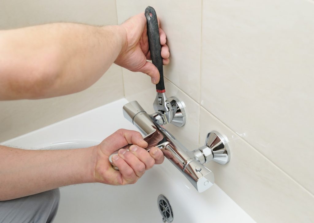 Sanitärinstallateur montiert Mischbatterie