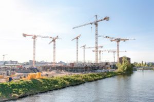 Baukräne auf einer Baustelle an einem Fluss