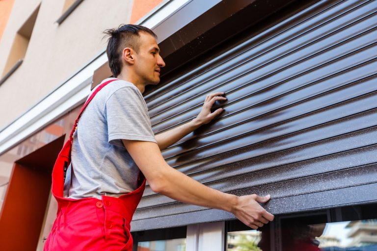 Fensterbauer montiert Rolladen am Fenster