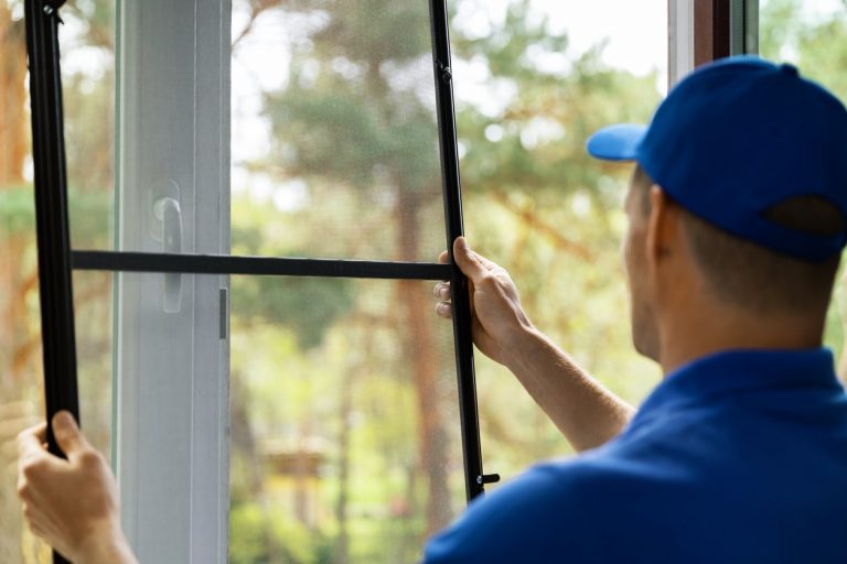 Fensterbauer montiert Insektenschutz am Fenster