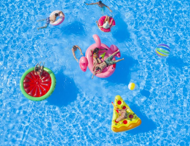 Menschen mit Poolspielzeug in einem Pool