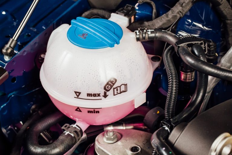 Kühlwasserbehälter mit rosa Kühlwasser im Motorblock eines Autos