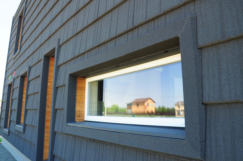Frontansicht eines Hauses mit Holzverkleidung und einem Passivhausfenster.