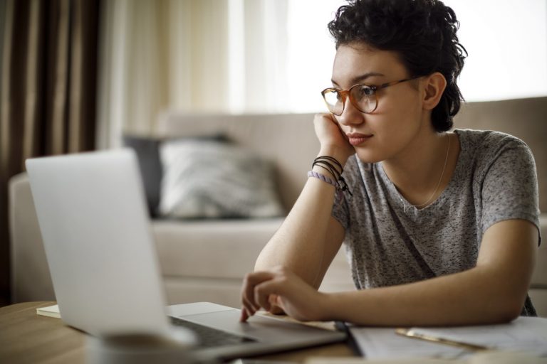 Frau arbeitet vor aufgeklappten Laptop