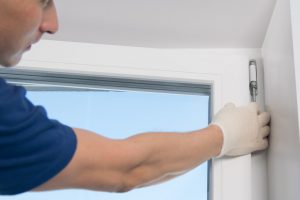 Fensterbauer beim Fenster aushängen mit weißen Handschuhen