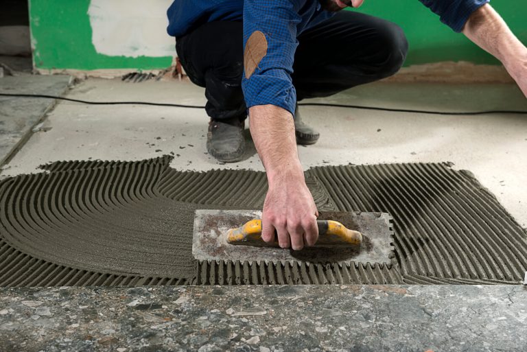 Arbeiter verlegt Granitfliesen
