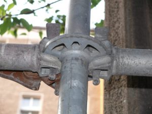Detailaufnahme eines Modulgerüst Knotens mit Riegeln und Vertikalstiel an einem Gerüstsystem aus Stahlrohr.