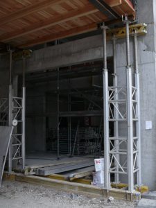  Raumgerüst für Sanierungs und Umbauarbeiten im Innenbereich mit sichtbaren Stützen und Baustellenmaterial im Hintergrund.