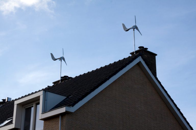 Zwei vertikal montierte Kleinwindkraftanlagen auf dem Satteldach eines Wohnhauses zur dezentralen Stromerzeugung.
