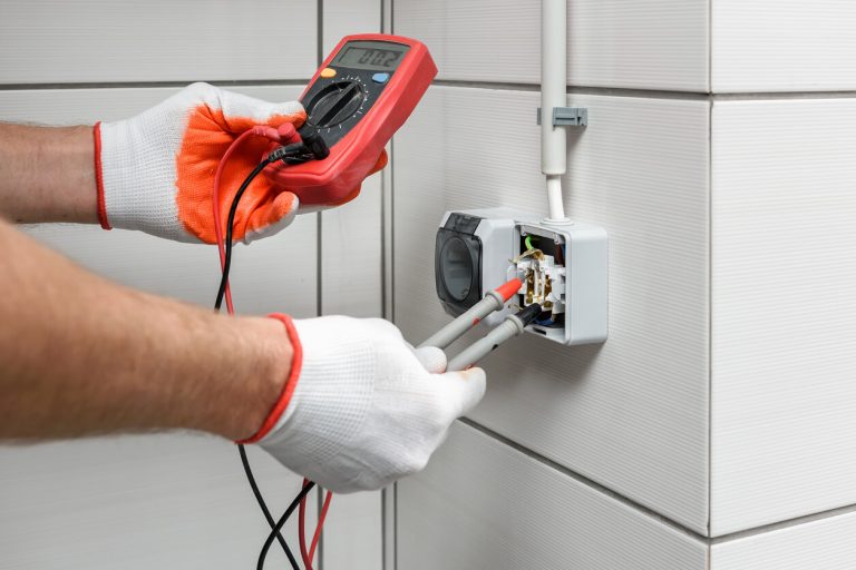 Techniker überprüft die Spannung mit einem Spannungsmessgerät