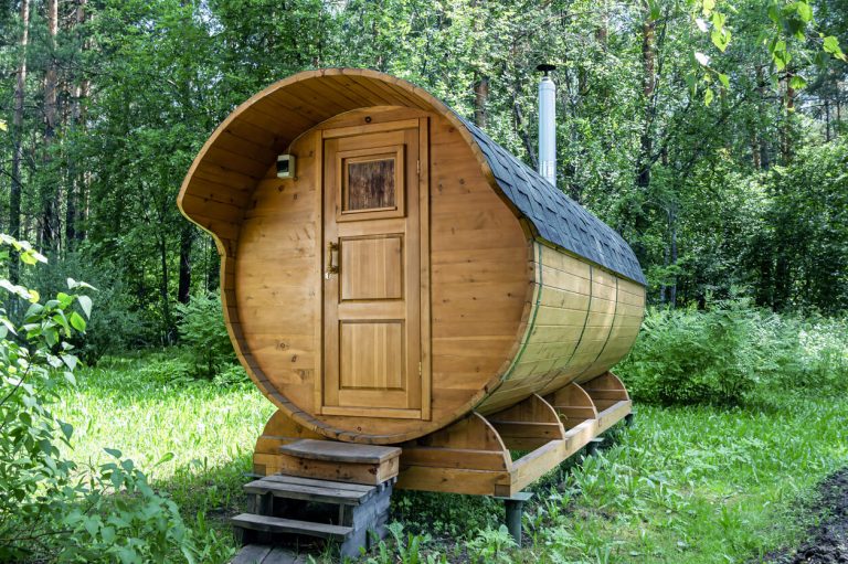 runde Fasssauna im grünen Garten