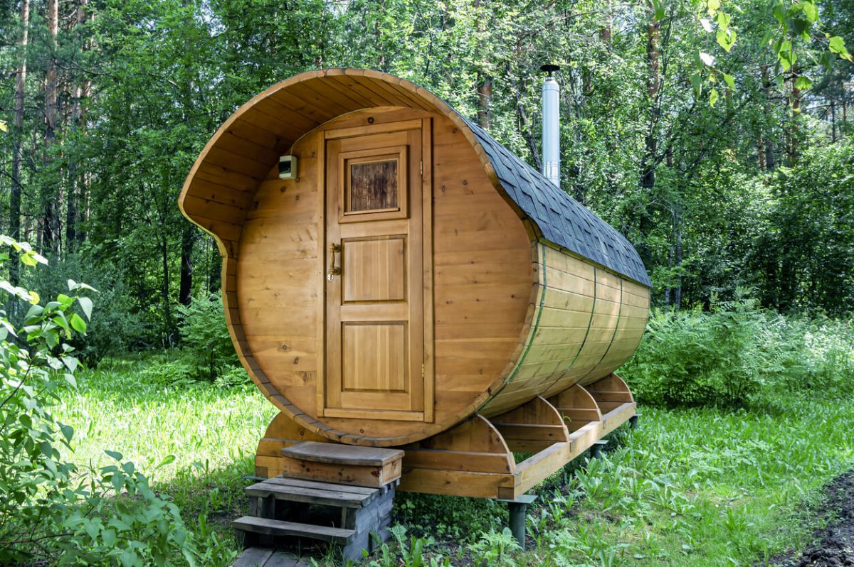 runde Fasssauna im grünen Garten