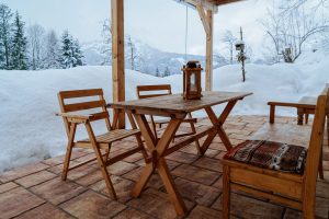Terrasse mit Holzgarnitur vor winterlicher Landschaft