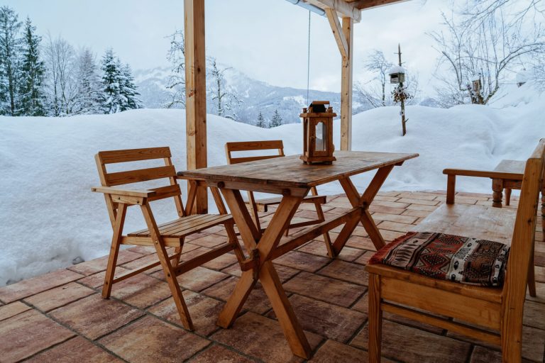 Terrasse mit Holzgarnitur vor winterlicher Landschaft