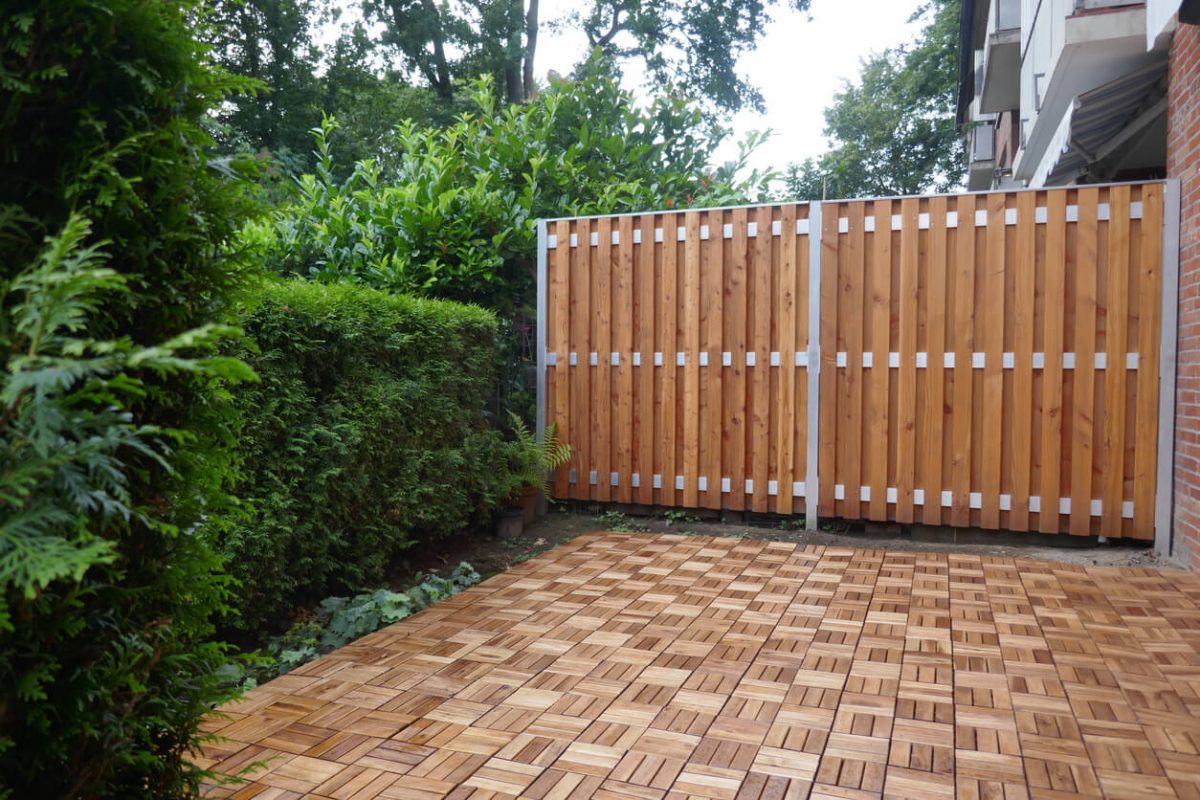 Terrasse mit Holzfliesen und Holztrennwand