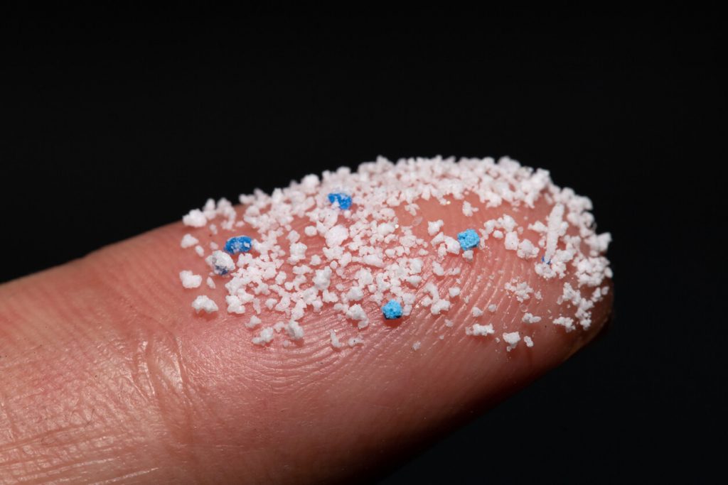 Mikroplastikpartikel auf Fingerspitze