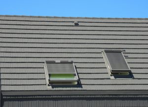 Hausdach mit Dachfenstern und Dachfenstermarkise als Sonnenschutz