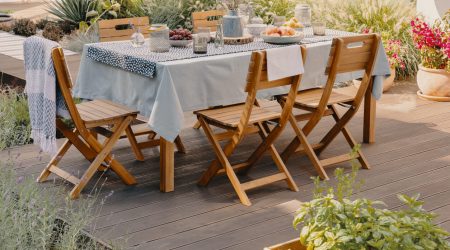 Holztisch und Holzstühle auf einer Terrasse