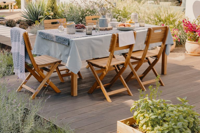 Holztisch und Holzstühle auf einer Terrasse
