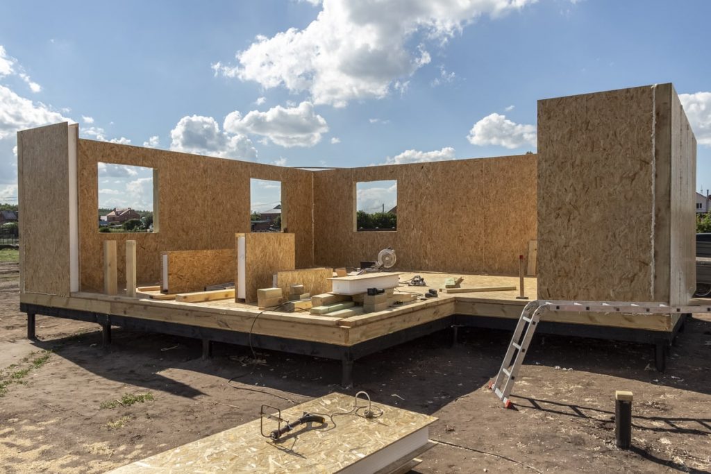 Holztafelbau Fertighaus im Aufbau auf einem Baugrund